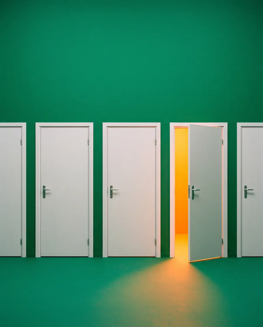 A row of white doors on green, one standing open